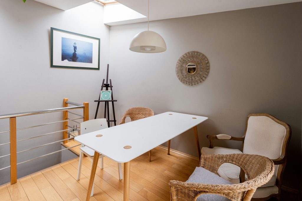 a room with a table, chairs and pictures on the wall